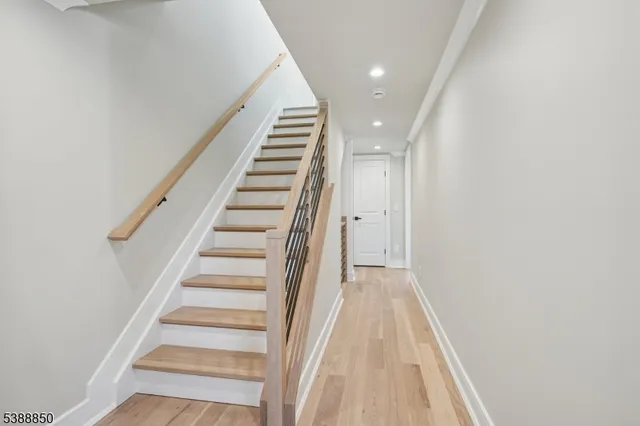 a view of a hallway with wooden floor and staircase
