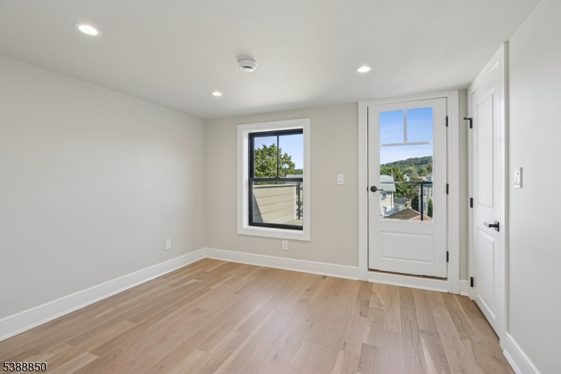 27 Willow Street, Unit A Millburn, NJ 07041 - Photo 37 of 50 an empty room with wooden floor and windows