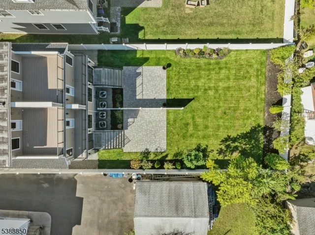 an aerial view of residential houses with outdoor space and trees