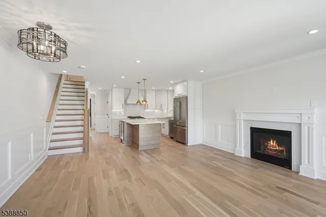 a kitchen with stainless steel appliances granite countertop a refrigerator a sink a stove and white cabinets