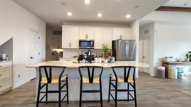 a kitchen with kitchen island a dining table and chairs