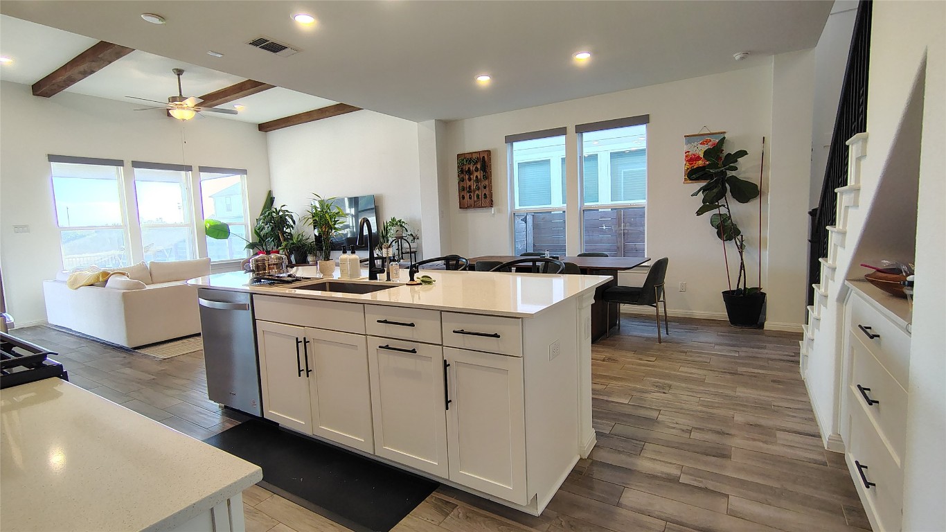 316 Turnbuckle Bend Leander, TX 78641 - Photo 6 of 21 a large white kitchen with stainless steel appliances a large counter top a couch and a view of living room