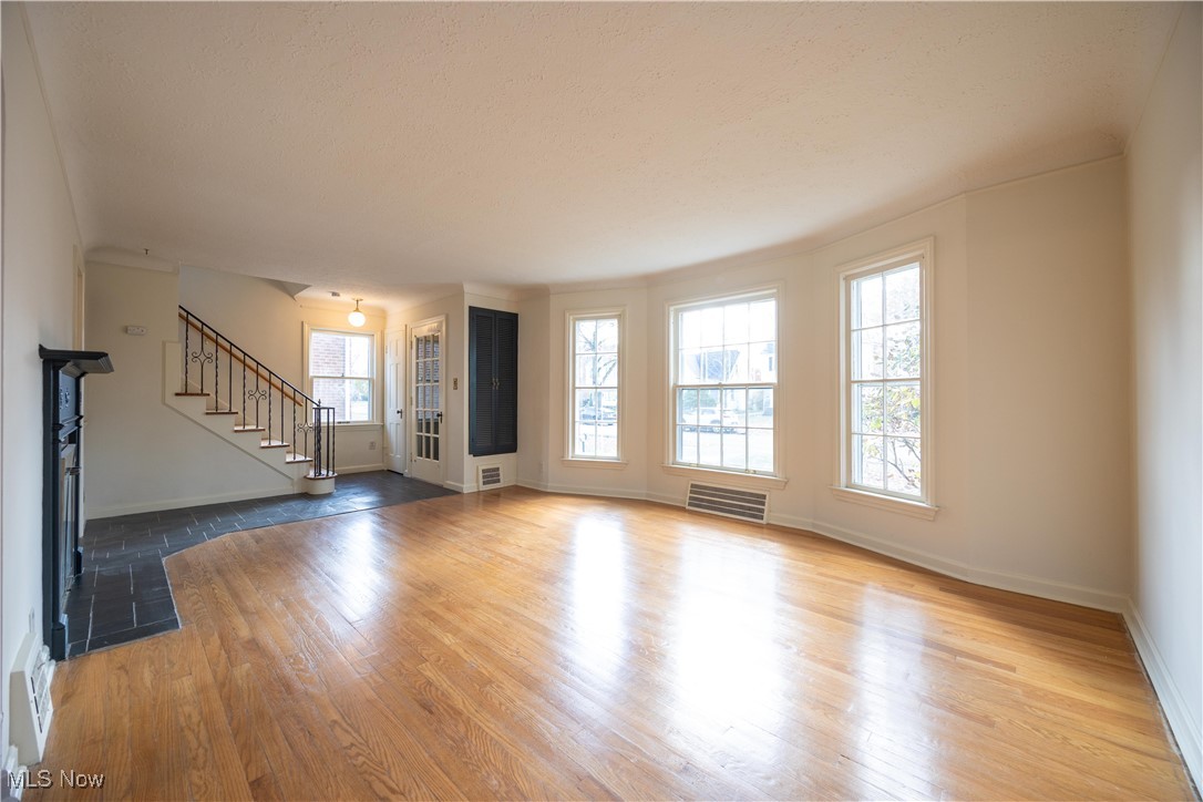 3797 Northwood Road Cleveland, OH 44118 - Photo 7 of 49 Unfurnished living room with stairway, light wood finished floors, and a fireplace