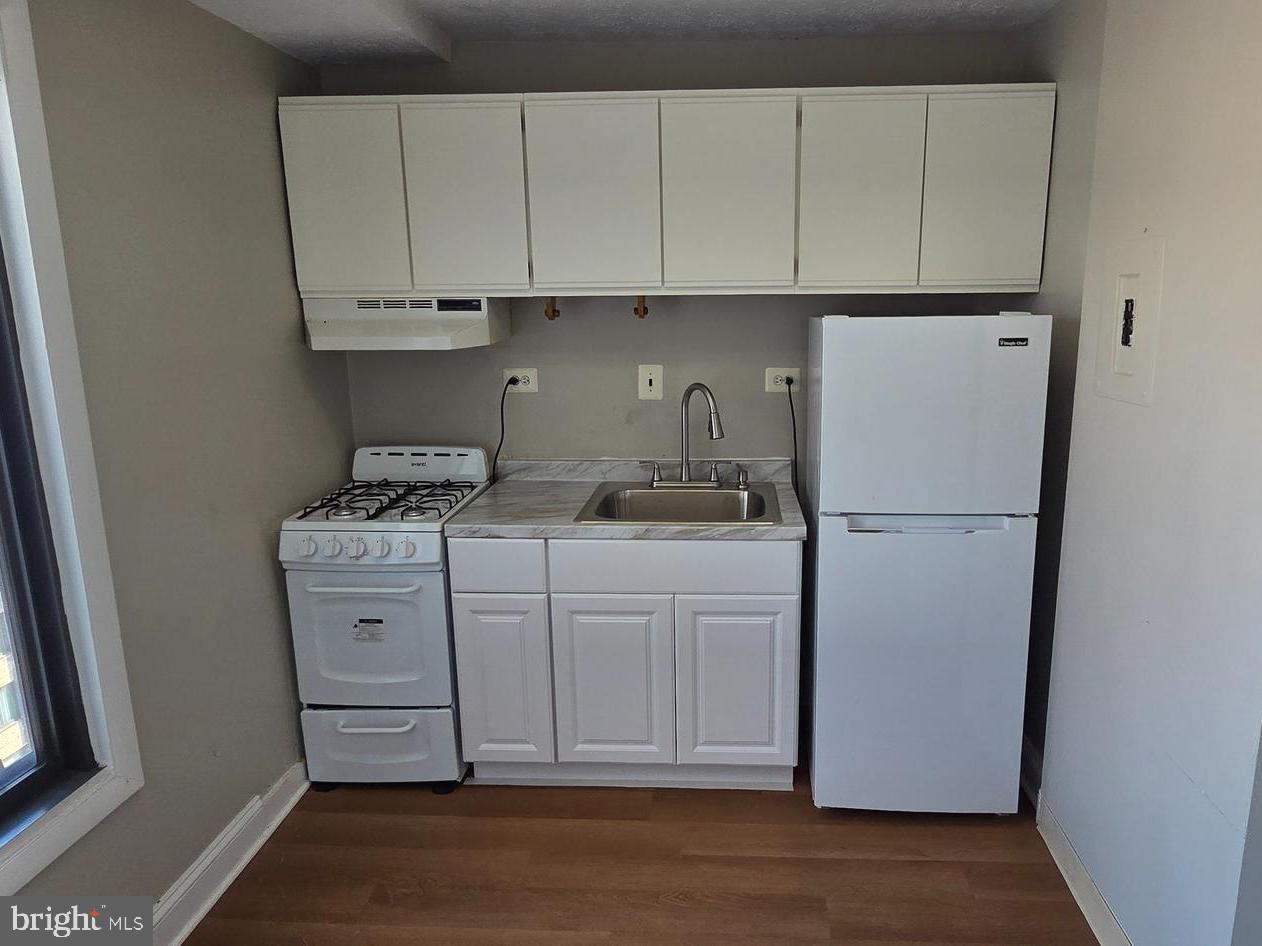 1440 N Street Northwest, Unit 1011 Washington, DC 20005 - Photo 4 of 14 a kitchen with appliances cabinets and a counter top space