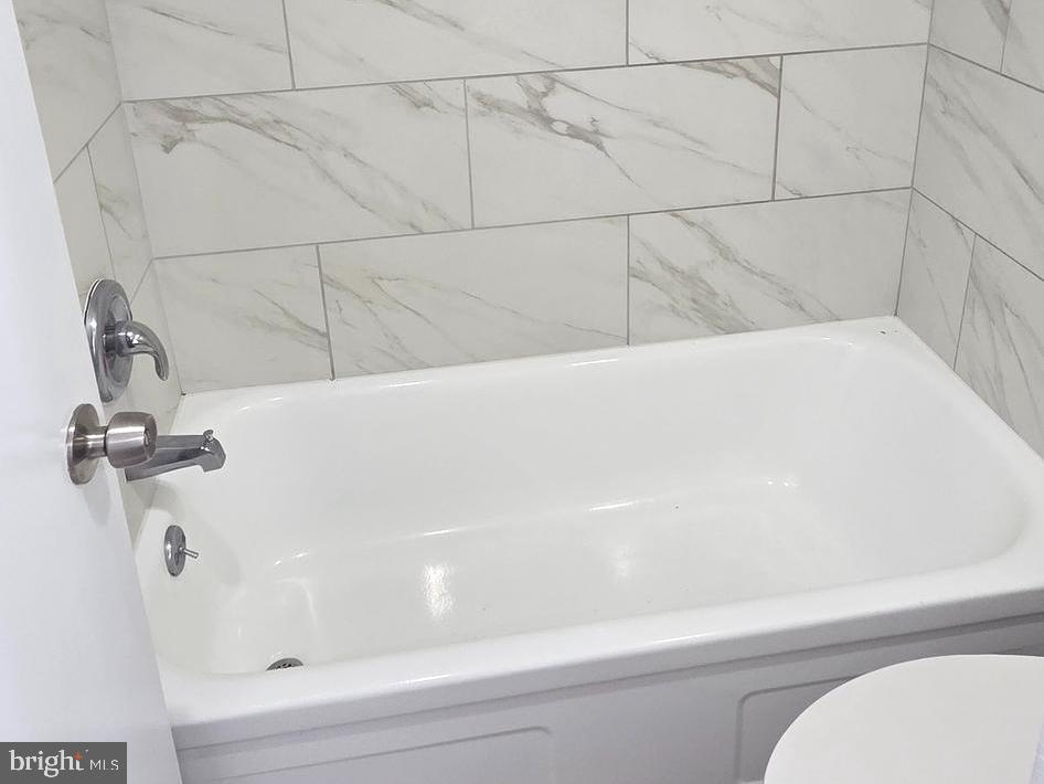 1440 N Street Northwest, Unit 1011 Washington, DC 20005 - Photo 6 of 14 a bathroom with a white bathtub