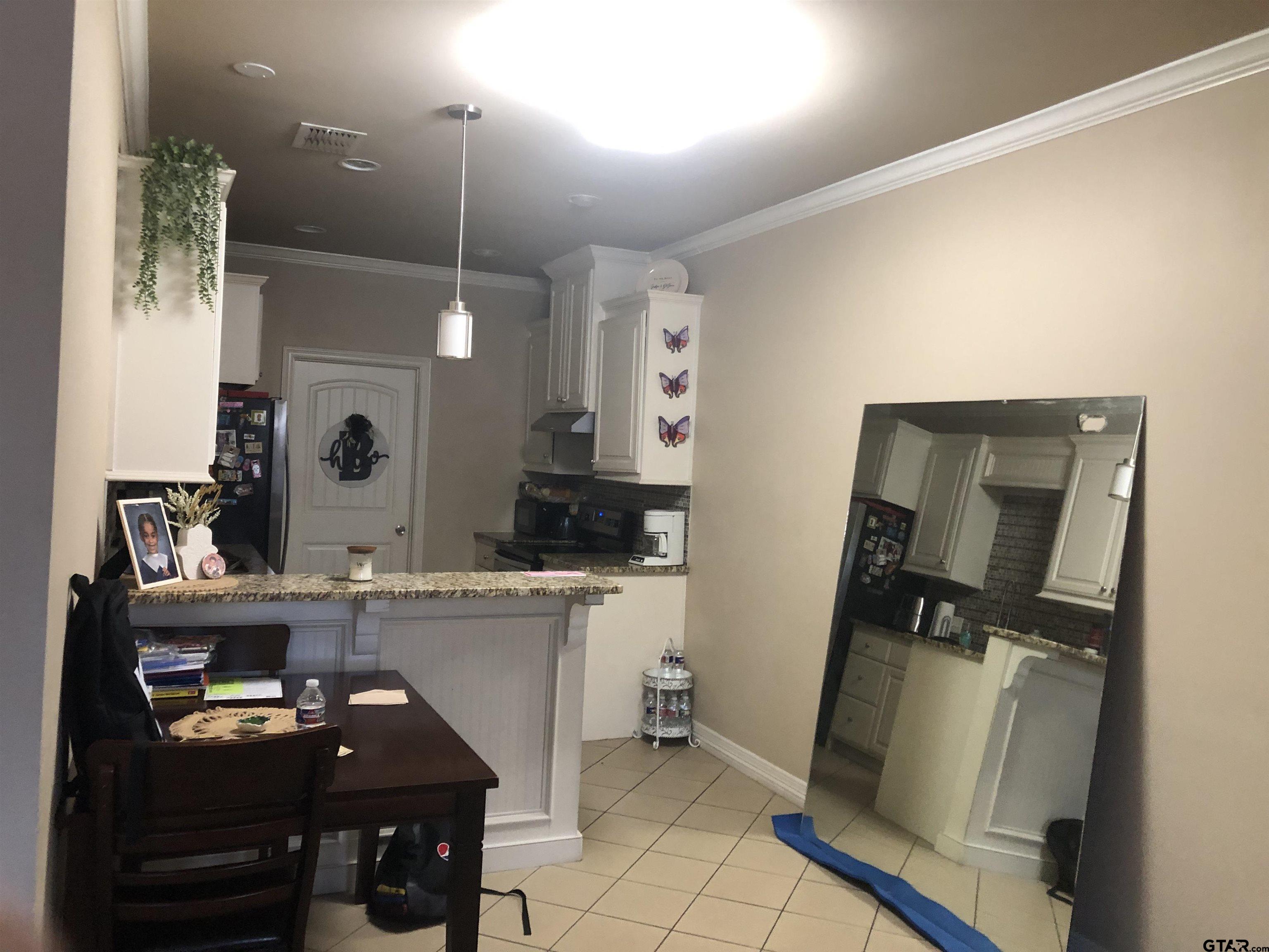 223 South Fenton Avenue Tyler, TX 75702 - Photo 4 of 9 a room with furniture a mirror and clock on wall