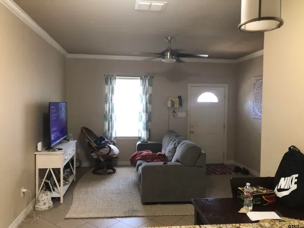 a living room with furniture a chandelier and a window