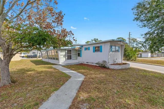 a view of a house with backyard and tree