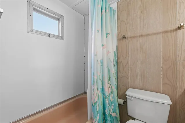 a bathroom with a toilet and a shower curtain