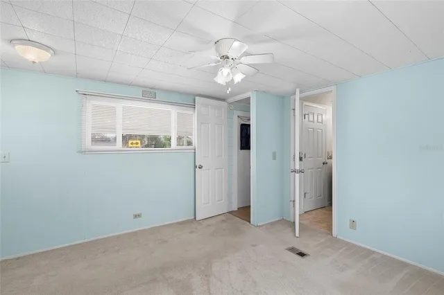 an empty room with fan and windows