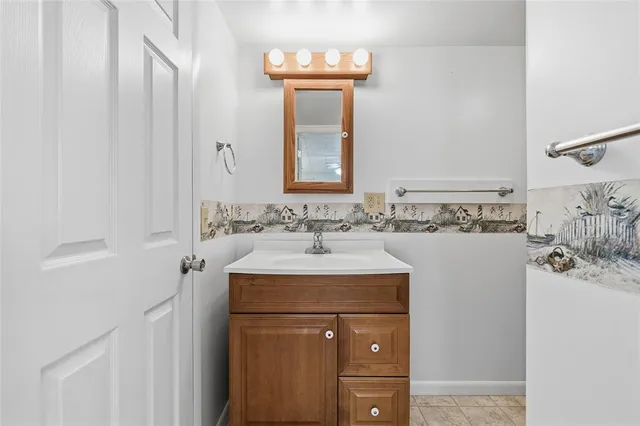 a bathroom with a sink vanity and a mirror