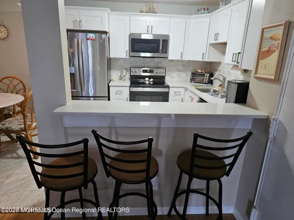 a kitchen with stainless steel appliances a refrigerator sink and microwave