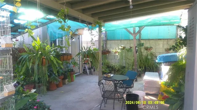a view of a patio with table and chairs potted plants