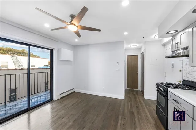 a kitchen with stainless steel appliances granite countertop a refrigerator a stove a sink and a large window