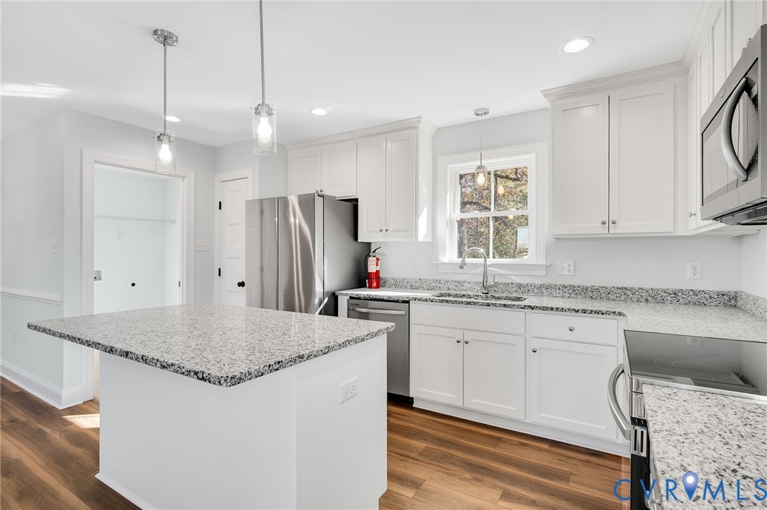 2321 Rock Island Road Scottsville, VA 24590 - Photo 12 of 24 a kitchen with stainless steel appliances granite countertop a sink a stove a refrigerator and island with wooden floor