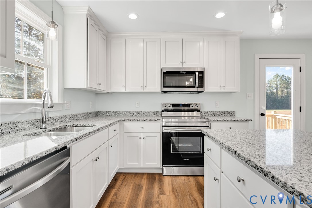 2321 Rock Island Road Scottsville, VA 24590 - Photo 14 of 24 a kitchen with granite countertop a sink stainless steel appliances and white cabinets