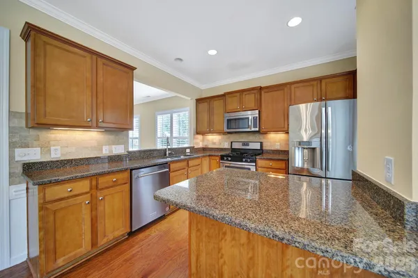 a kitchen with wooden cabinets and stainless steel appliances