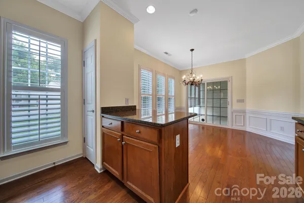 a kitchen with stainless steel appliances granite countertop a stove and a wooden floors