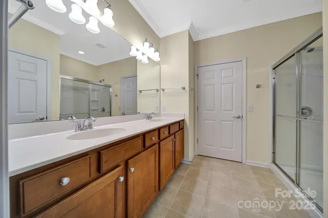 a spacious bathroom with a double vanity sink mirror and shower