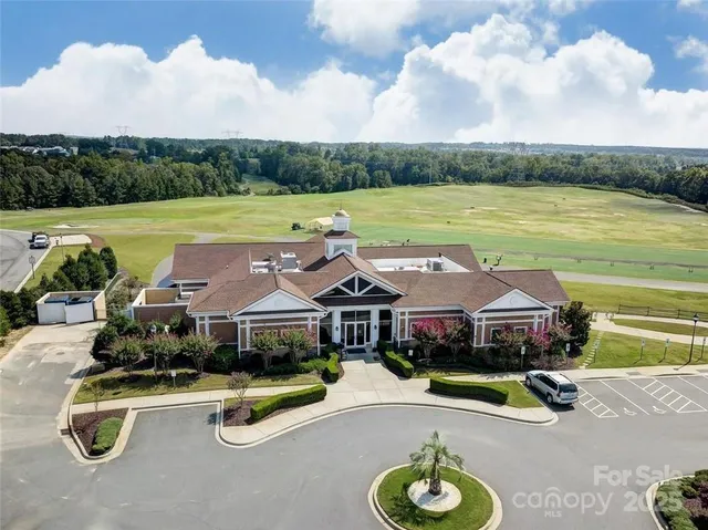 an aerial view of a house with swimming pool and green space