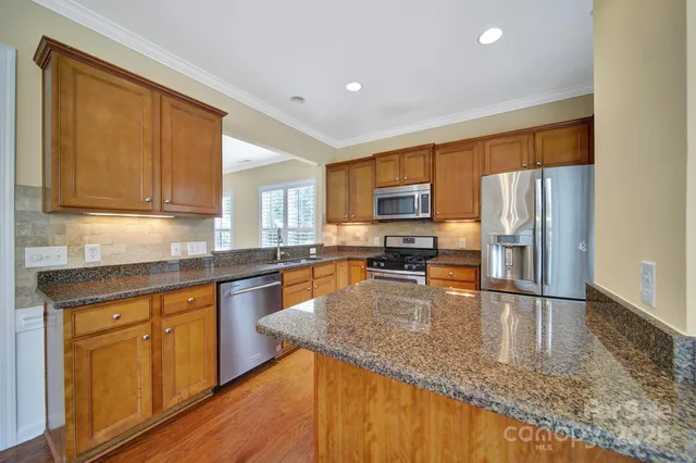 a kitchen with wooden cabinets and stainless steel appliances