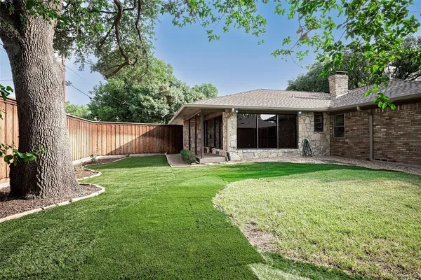 a view of a backyard with a large tree