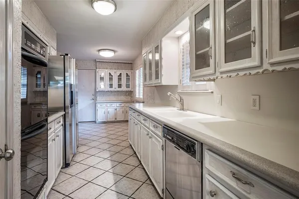 a kitchen with white cabinets a sink and a window