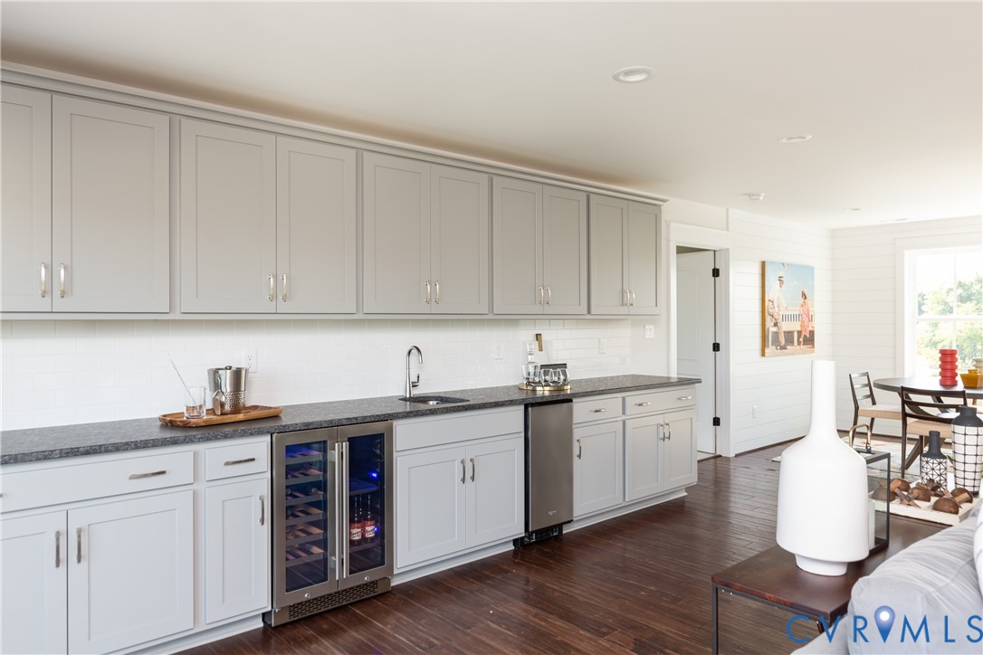 16852 Sheppards Fold Way Beaverdam, VA 23015 - Photo 23 of 30 a kitchen with a sink dishwasher a stove and white cabinets with wooden floor