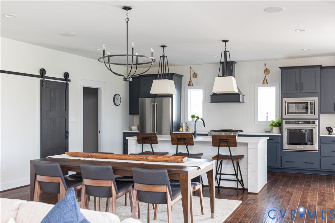 16852 Sheppards Fold Way Beaverdam, VA 23015 - Photo 6 of 30 a kitchen with stainless steel appliances granite countertop a kitchen island a stove a table and chairs