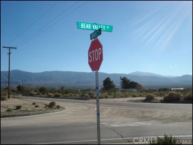 0 Oasis Road Pinon Hills, CA 92372 - Photo 2 of 14 a front view of a house with a yard and mountain view in back