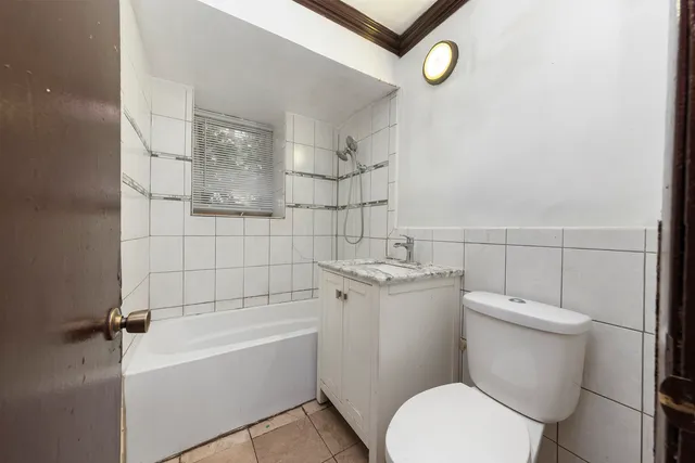 a white toilet sitting next to a bath tub and shower