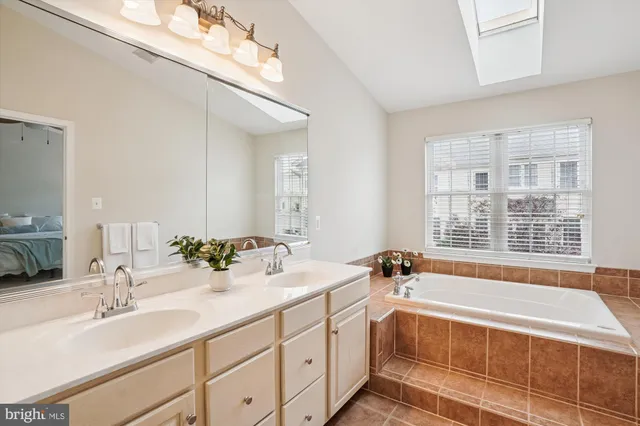 a spacious bathroom with a double vanity sink a mirror and a shower