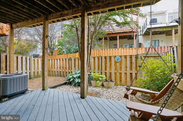 a view of a deck with chairs a barbeque with wooden floor and fence