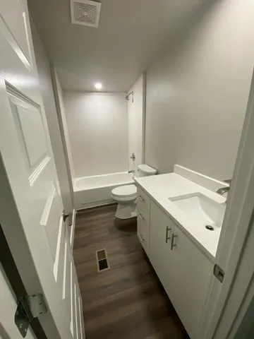 a bathroom with a double vanity sink toilet and shower