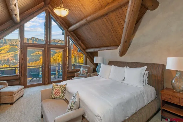 a bedroom with a bed couch and a large window