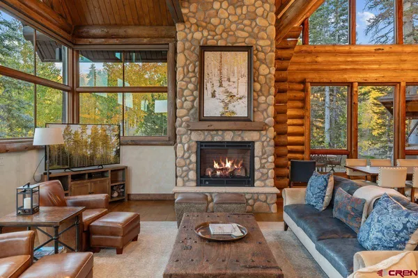 a living room with furniture a fireplace and a floor to ceiling window