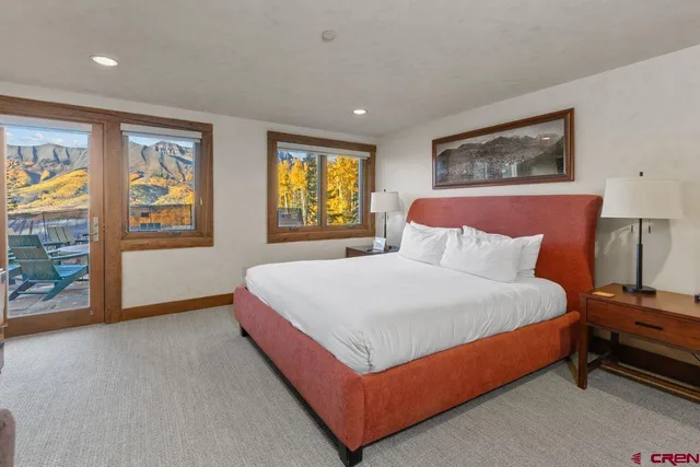 a bedroom with a bed lamp and paintings on the wall