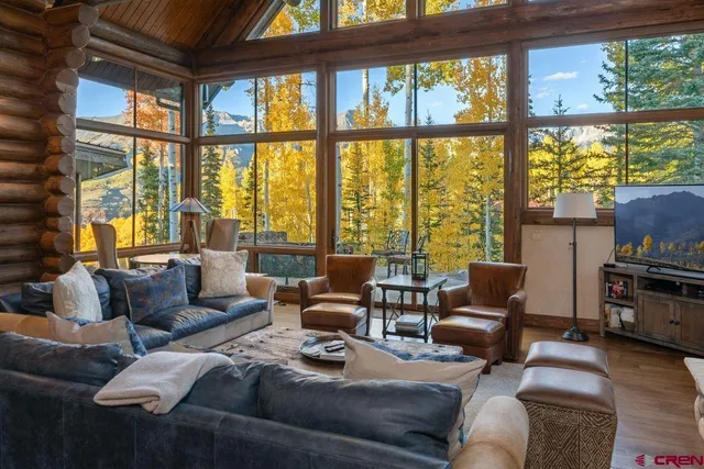 a living room with furniture and floor to ceiling windows