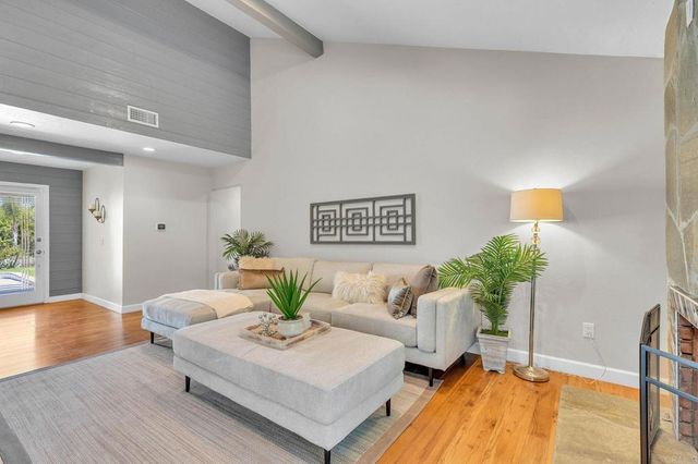 a living room with furniture potted plant and a large mirror