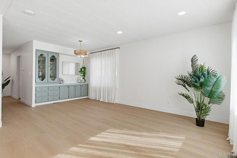 650 South Rancho Santa Fe Road, Unit 291 San Marcos, CA 92078 - Photo 6 of 48 an empty room with potted plants and wooden floor