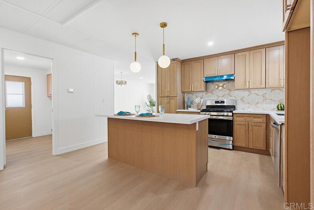 650 South Rancho Santa Fe Road, Unit 291 San Marcos, CA 92078 - Photo 9 of 48 a kitchen with stainless steel appliances kitchen island granite countertop a stove a sink and a refrigerator