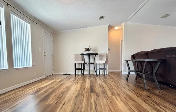 a workspace room with wooden floor table and chairs
