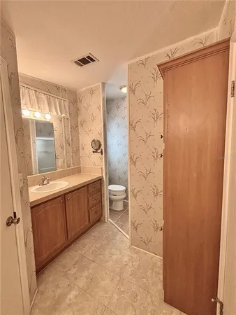 a large bathroom with a double vanity sink toilet mirror and shower