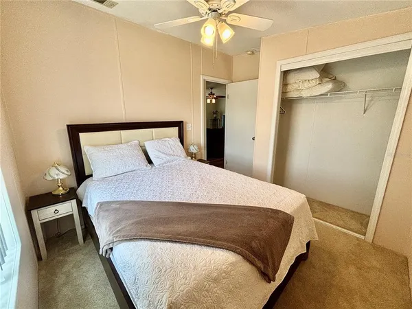 a bedroom with a bed and a ceiling fan