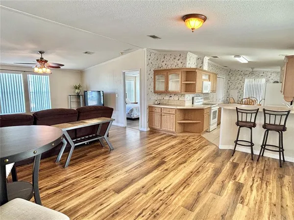a living room with dining room and wooden floor