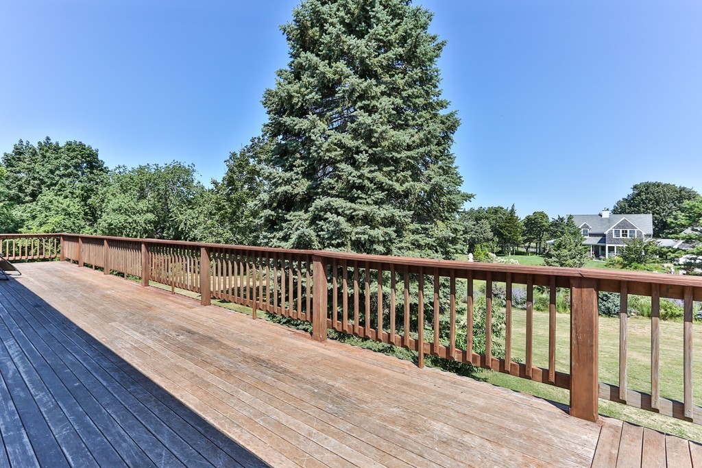 75 Deacon Court Barnstable, MA 02630 - Photo 28 of 30 a balcony with wooden floor and trees in the background
