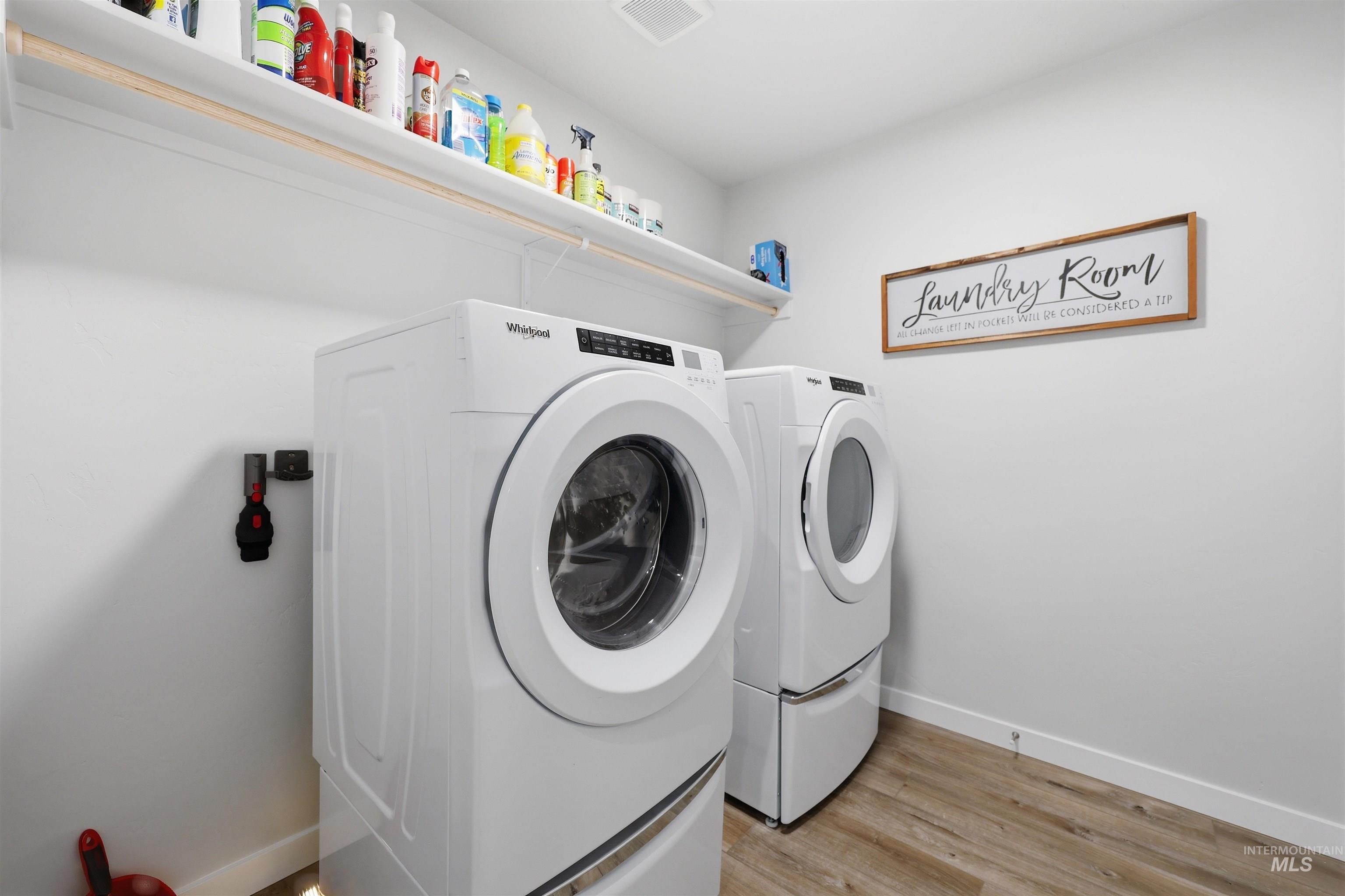 3811 West Maypearl Street Meridian, ID 83642 - Photo 29 of 39 Dedicated laundry area featuring a white front-loading washer and dryer, wood-finish flooring, and an overhead white storage shelf