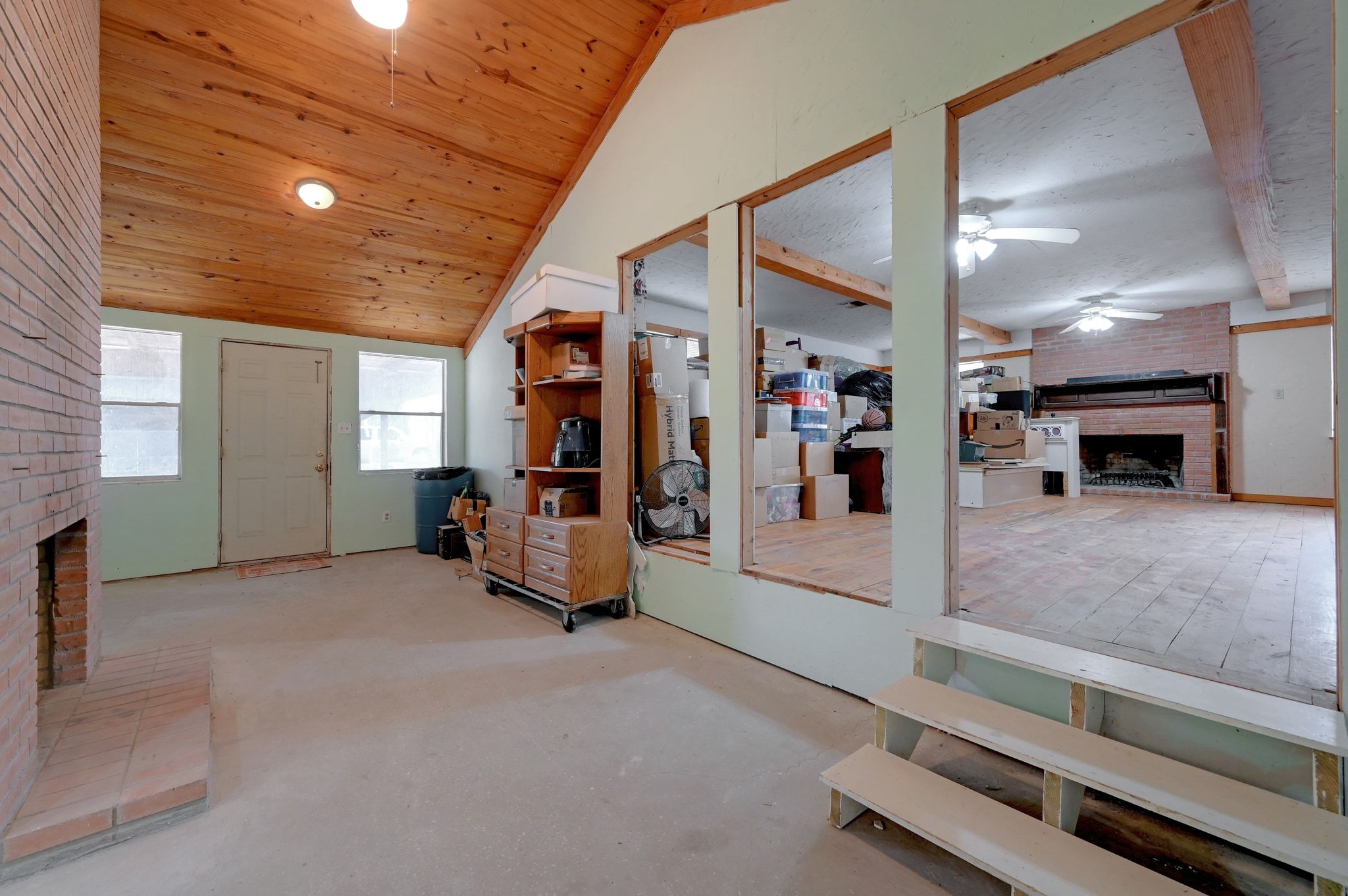 4598 Highway 173 Devine, TX 78016 - Photo 7 of 40 Entrance foyer with a fireplace, a ceiling fan, vaulted ceiling, and wood ceiling