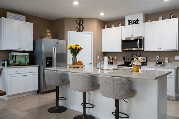 a kitchen with a sink refrigerator and microwave