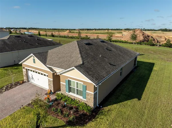 an aerial view of residential houses with outdoor space and ocean view